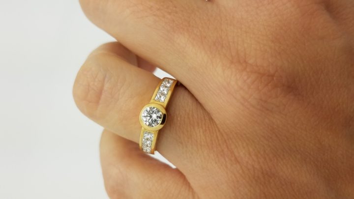 18K	Yellow Gold	Channel band	1.10	ct.	R+PR	Cut	Diamond	H	VS2	Bezel-Set	Solitaire with Accents	Engagement-Ring