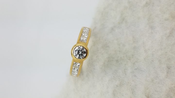 18K	Yellow Gold	Channel band	1.10	ct.	R+PR	Cut	Diamond	H	VS2	Bezel-Set	Solitaire with Accents	Engagement-Ring